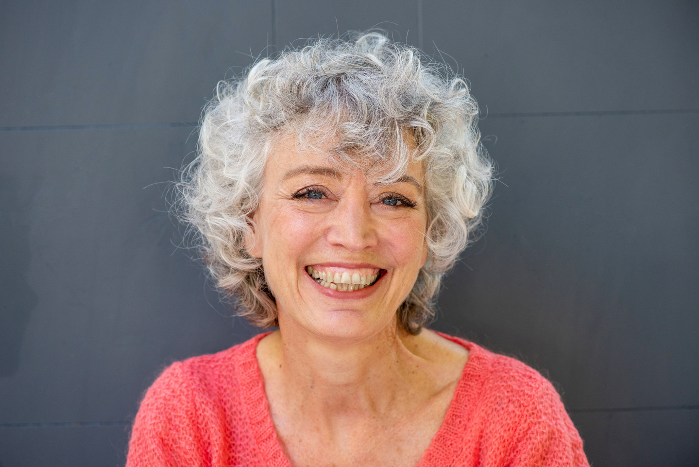 Close up Happy Older Woman Smiling against Gray Wall
